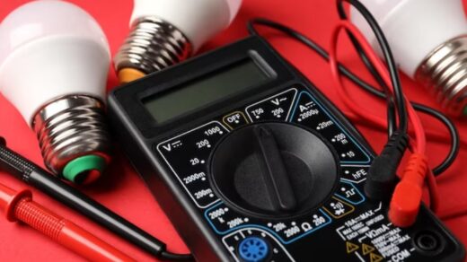 a multimeter and three energy-saving bulbs in the red background