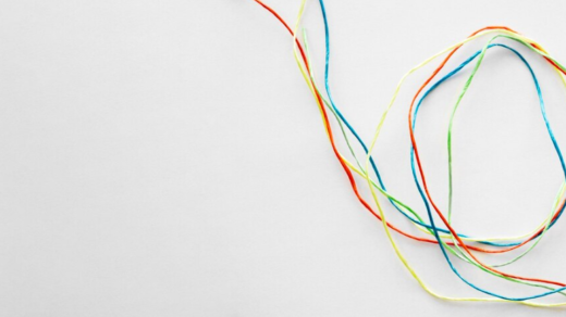 Multi-colored red, green, blue, and yellow thin wires meandering on a white background