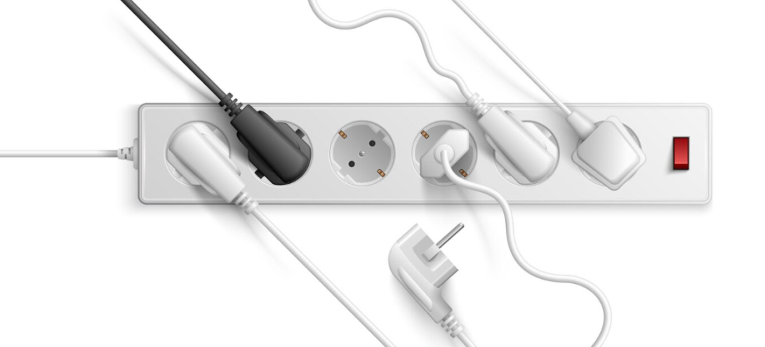 A white power strip, various plugged-in cables, and a red switch on the far right