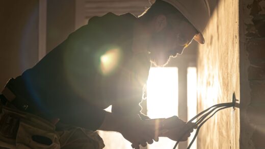 Worker is cutting wires with pliers