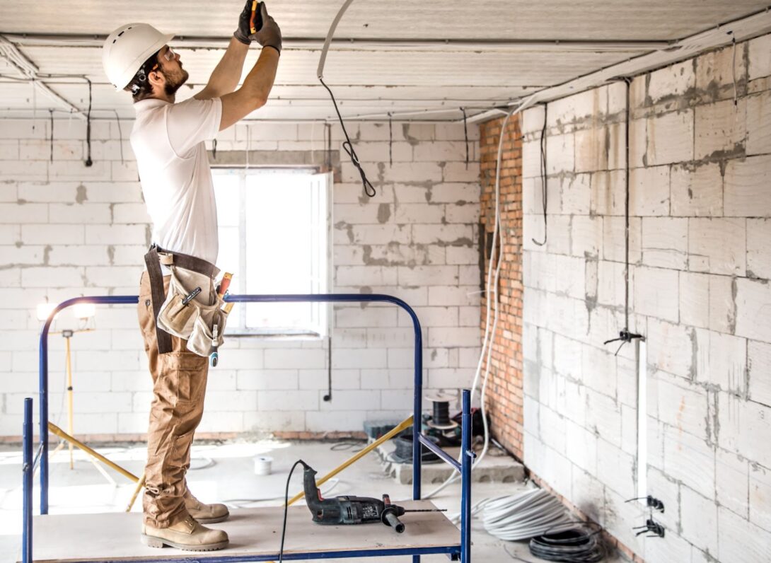 Electrician working with cable on the construction site